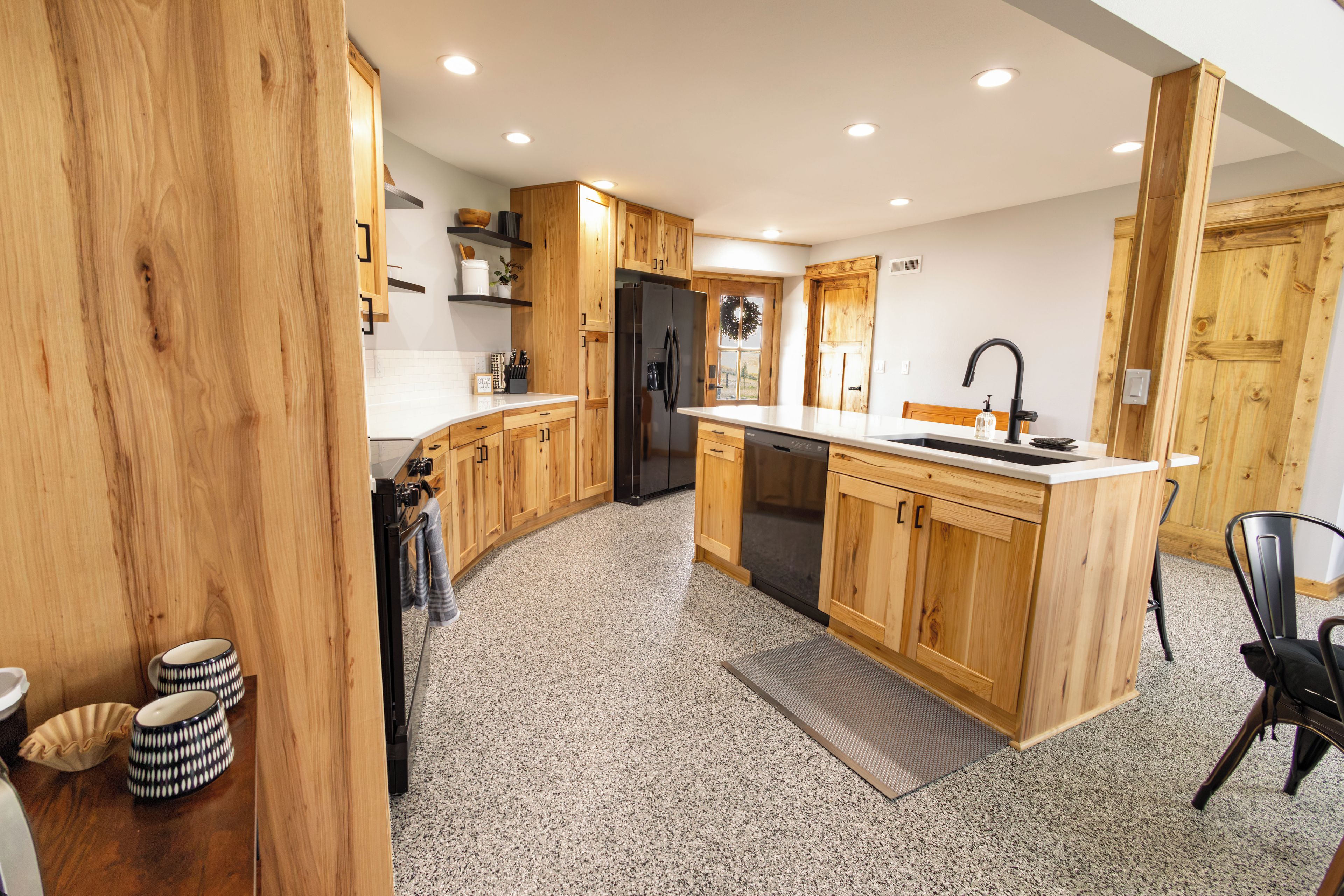 Una cocina moderna con armarios de madera, un refrigerador de acero inoxidable y un lavavajillas empotrado.