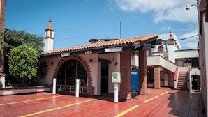 A building with a red-tiled roof, a sign indicating a vacancy, and a mailbox.