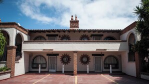 A building with a symmetrical facade, multiple arched windows, and a central chimney.