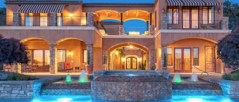 Une maison à plusieurs étages avec une piscine et une fontaine.