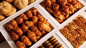 Eine Auswahl an Backwaren, darunter Brot, Croissants und Zimtschnecken.