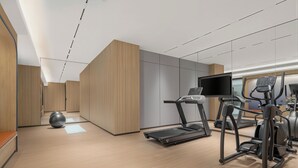 Ein modernes Fitnessstudio mit Laufbändern, Crosstrainern und einem Ergometer.