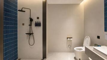 A modern bathroom with a shower, toilet, and sink.