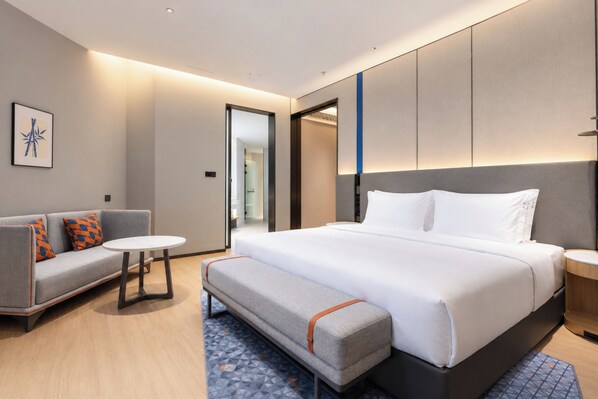 A modern hotel room with a large bed, a sofa, a small table, and a bench. - Holiday Inn Express Dujiangyan Ctc By Ihg (Chengdu)