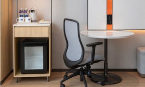 A modern office chair with a mesh backrest and a desk with a coffee maker, a kettle, and a mug. - Holiday Inn Express Dujiangyan CTC (Chengdu)