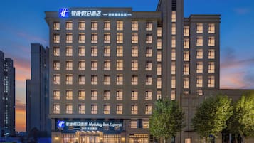 Un hotel de varios pisos con un letrero destacado de Holiday Inn Express, que presenta una fachada moderna con ventanas regularmente distribuidas y una línea de techo plana.