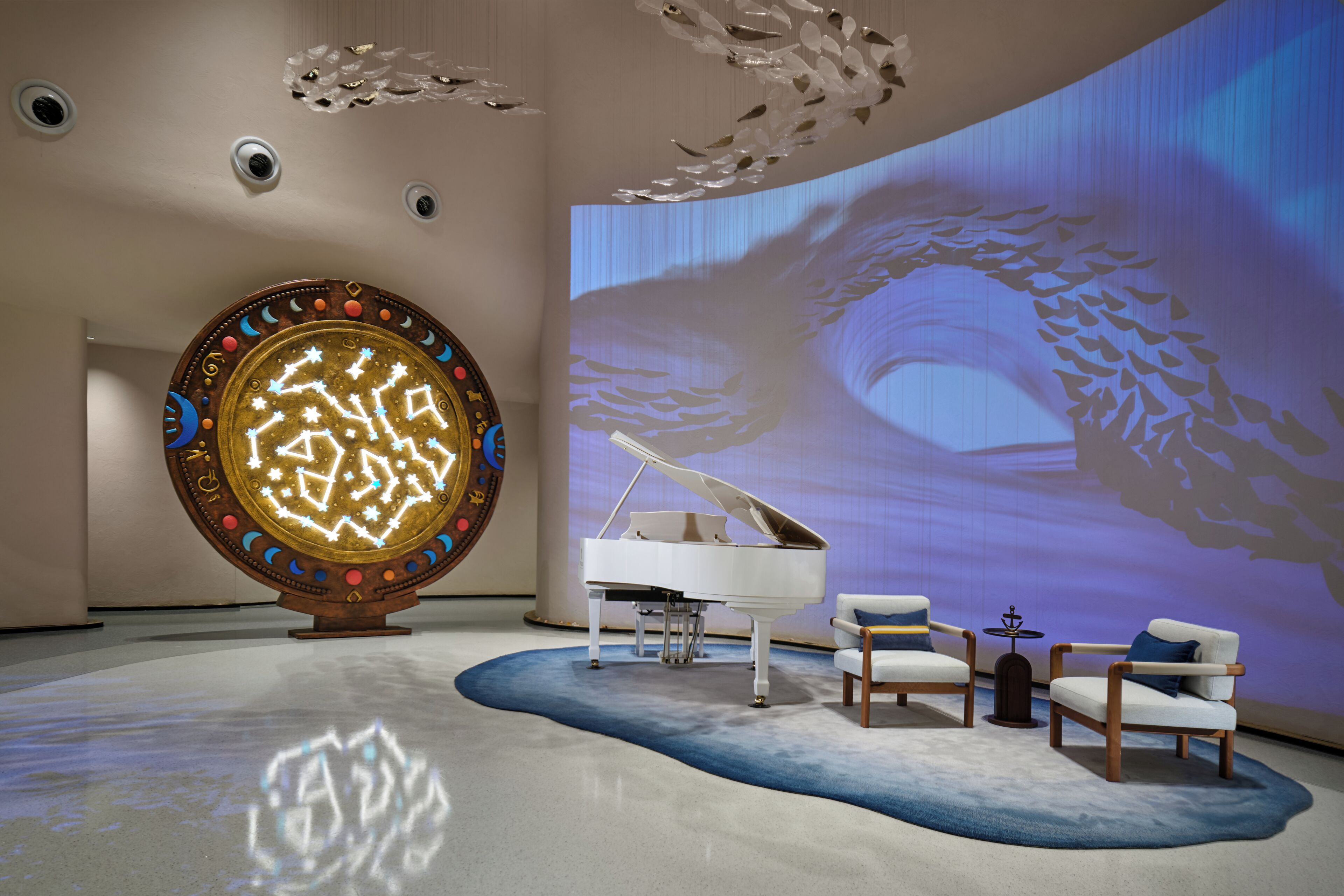 A modern interior with a grand piano, a large decorative wall, and a projection screen displaying a nature scene.