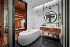 Ein modernes Badezimmer mit einer freistehenden Badewanne, einem Holzwaschtisch und einem großen Spiegel.