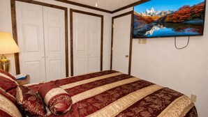 Une chambre à coucher avec un lit, une télévision et une lampe.