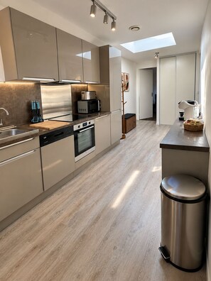 A modern kitchen with stainless steel appliances, a dishwasher, and a built-in oven.