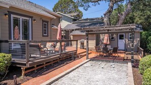 En boligejendom med en overdækket terrasse, udesiddeplads og et indhegnet område med en bænk.