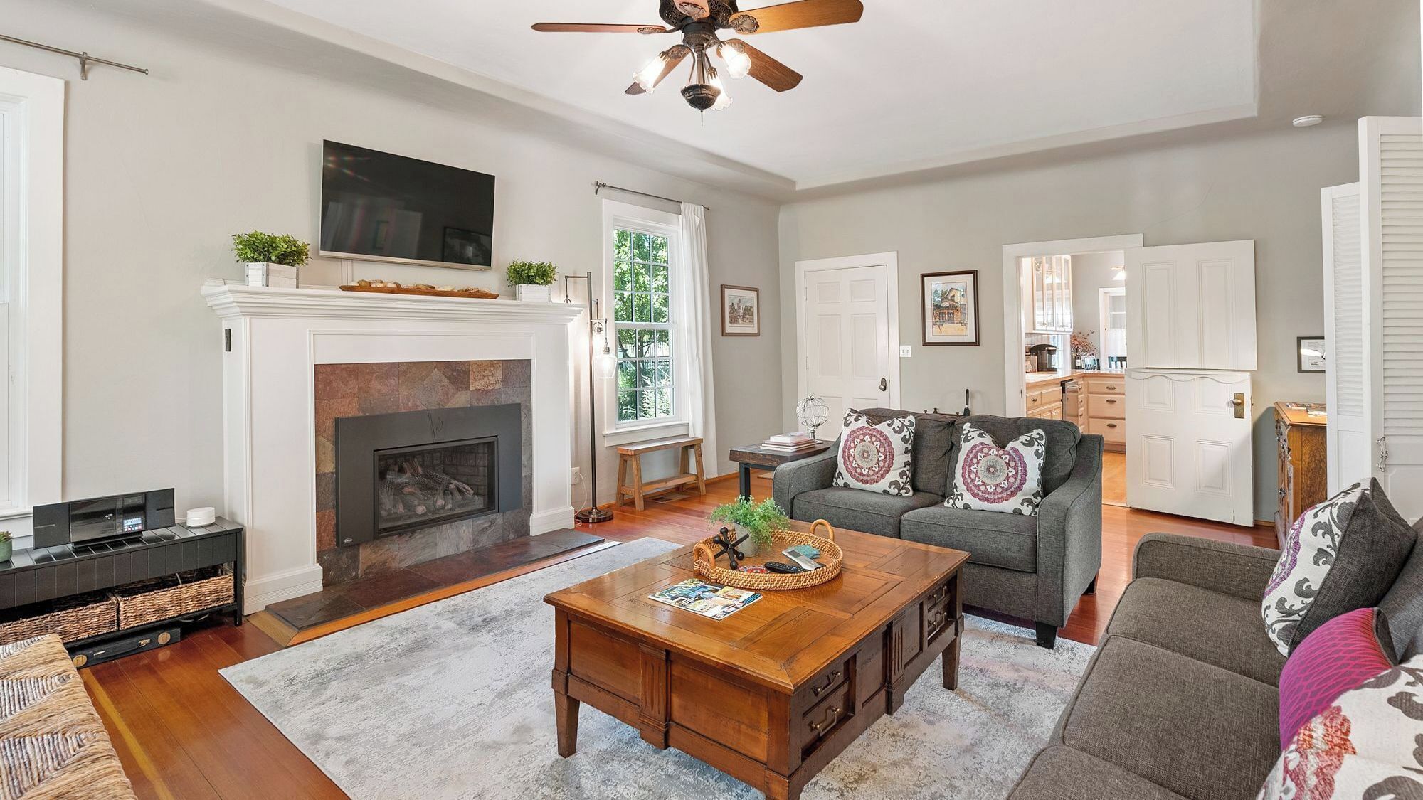 A living room with a fireplace, a sofa, a coffee table, and a television.