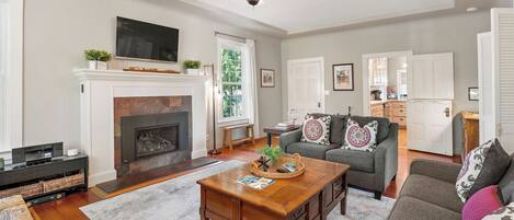 A living room with a fireplace, a sofa, a coffee table, and a television.