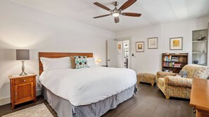 A bedroom with a bed, bedside table, lamp, ceiling fan, and a bookshelf. - Chateau Paso by Avantstay Pool Table + Private Deck Walk to Downtown Paso (Paso Robles)