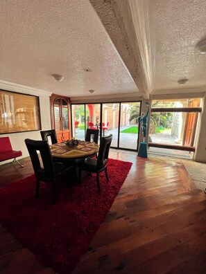 A dining area with a round table, chairs, and a red rug. - Casa Sol (Mexico City)