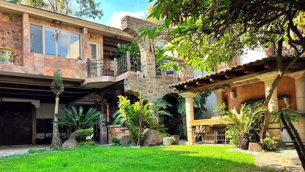 A two-story house with a stone facade, a covered patio area, and a well-maintained lawn. - Casa Sol (Mexico City)
