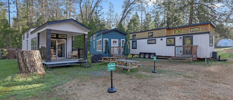 A row of mobile homes with a picnic table and a sign indicating Tiny Blanca Parking.