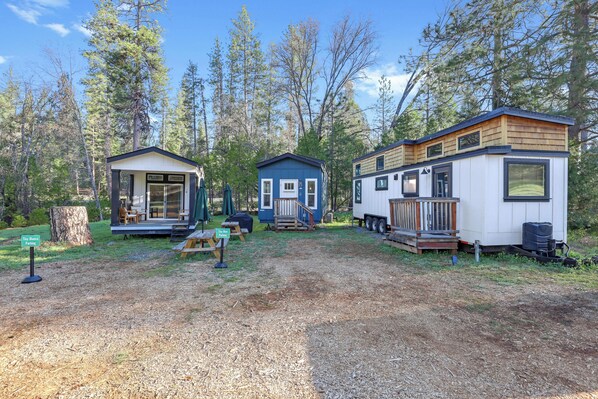 A row of mobile homes with a picnic table and a sign indicating Tiny Blue Parking.