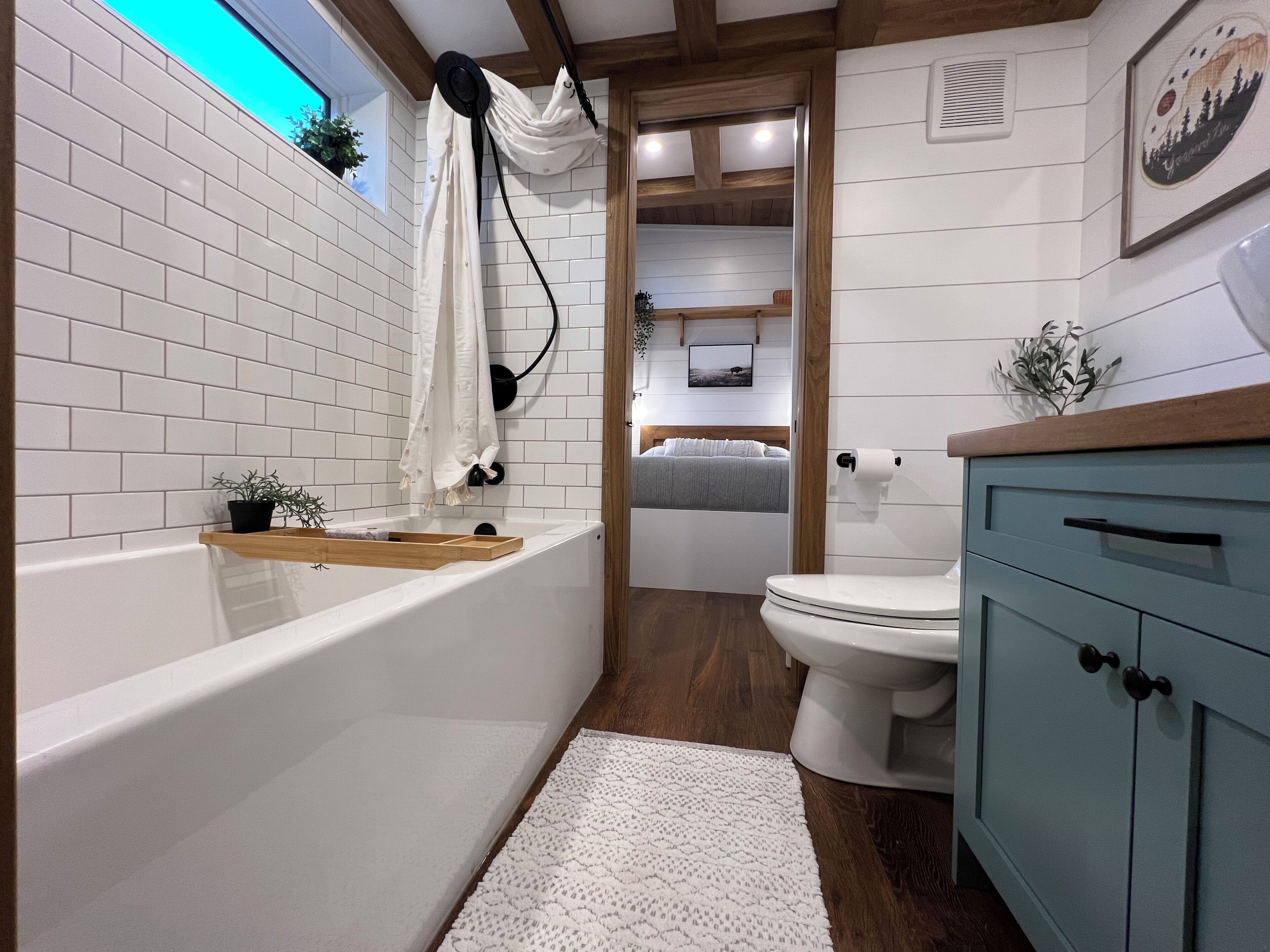 Baño con bañera, inodoro y tocador de madera.