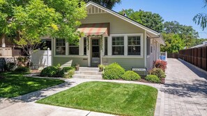 A single-story house with a front porch, a small front yard, and a street sign indicating 'DOWNTOWN'. - 13th Street Retreat by Avantstay Ensuite Suites + Sun Porch & Patio Downtown Paso Robles (Paso Robles)