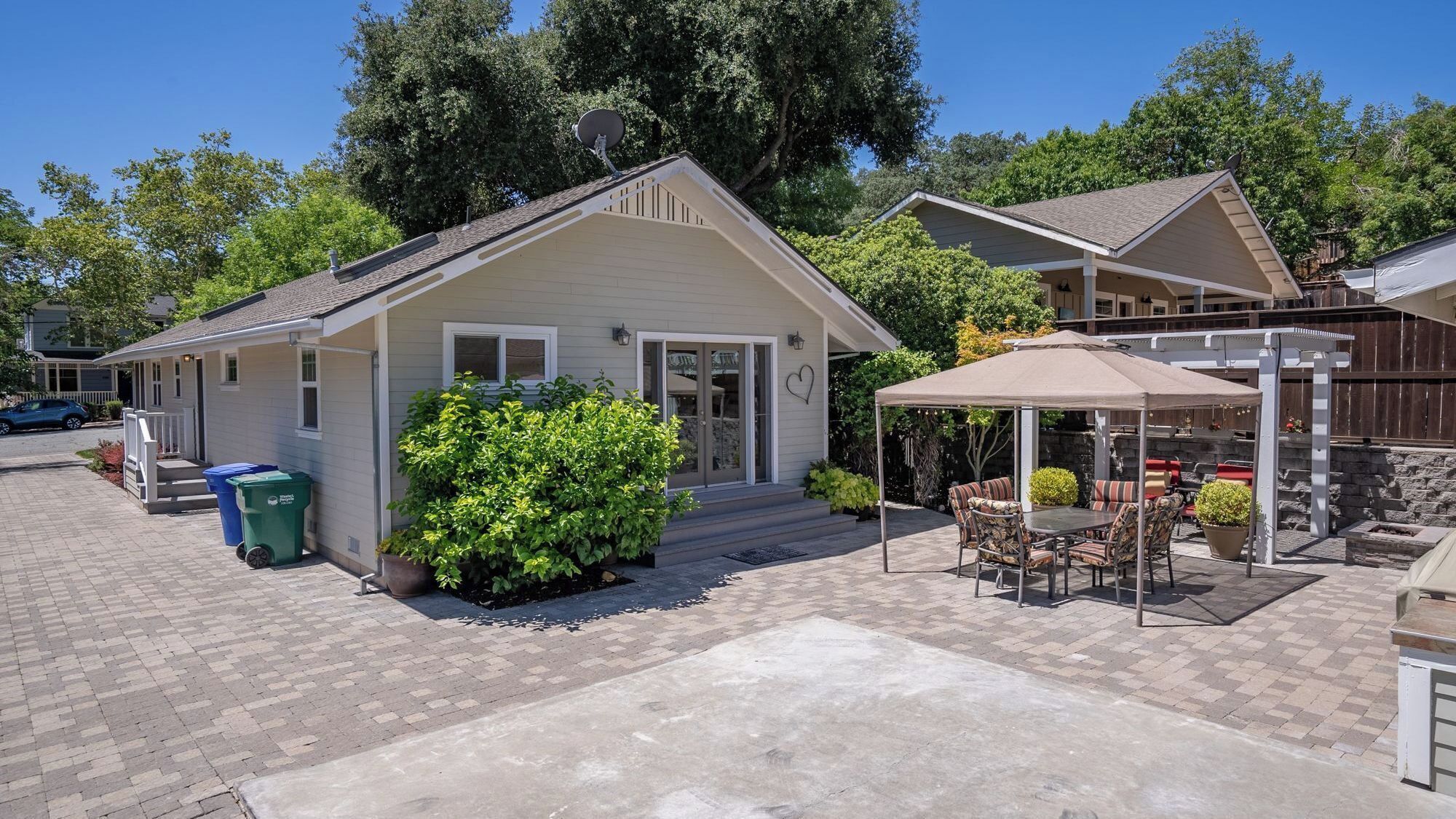 Une maison de plain-pied dotée d’un patio couvert, d’une porte d’entrée et d’un petit porche.