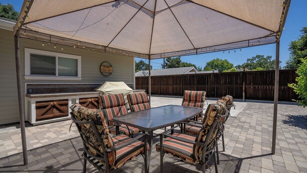 An outdoor patio with a table and chairs, a barbecue grill, and a covered area. - 13th Street Retreat by Avantstay Ensuite Suites + Sun Porch & Patio Downtown Paso Robles (Paso Robles)