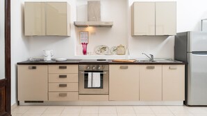 Una cocina moderna con horno empotrado, refrigerador de acero inoxidable e isla central con pileta.