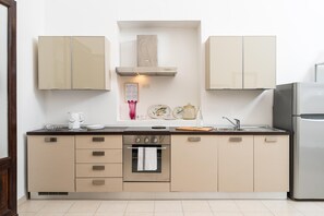 Eine moderne Küche mit Einbauofen, Edelstahlkühlschrank und einer zentralen Kochinsel mit Spüle.