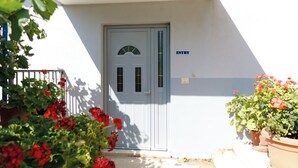 Una porta bianca con un cartello 'ENTRY', un'anta finestrata e una parete bianca.
