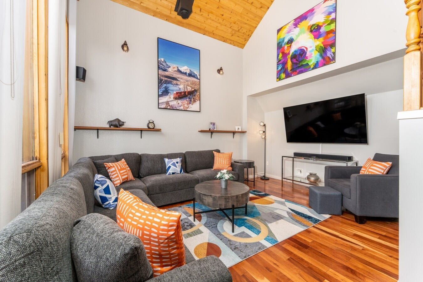 A modern living room with a sectional sofa, a coffee table, and a flat-screen TV.