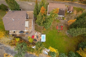 An aerial view of a residential property with a swimming pool, a hot tub, and a deck area.