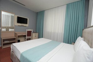 A hotel room with a bed, a desk, a chair, a television, and curtains. - Alis Hotel Baku (Baku)
