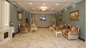 A spacious living room with a fireplace, two sofas, a coffee table, and a television. - Alis Hotel Baku (Baku)