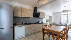 Eine moderne Küche mit Einbauofen, Kühlschrank und Holzschränken.