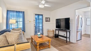 A living room with a sofa, a wooden coffee table, a television, and a refrigerator. - 7th Street Sanctuary by Avantstay Walk to Downtown + Sun Porch Paso Robles (Paso Robles)
