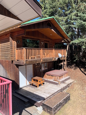 A wooden cabin with a balcony, a picnic table, and a covered outdoor seating area. - Small Waterfront Cabin on Little Lac Des Roches… pet friendly… moorage available (Bridge Lake)