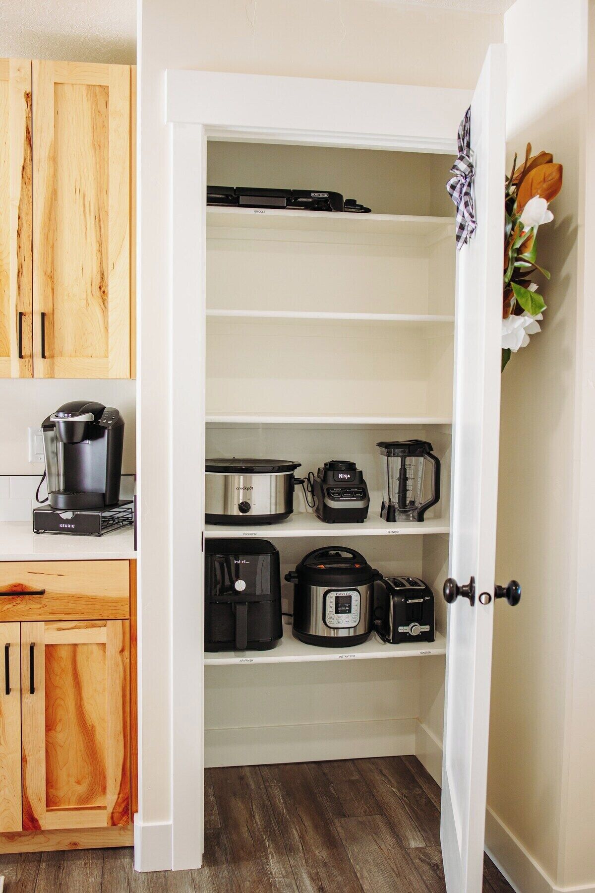 A kitchen with wooden cabinets, a coffee maker, a slow cooker, an air fryer, and a toaster.