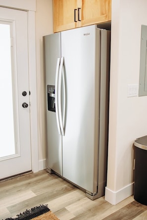 Ein Edelstahl-Kühlschrank mit separatem Gefrierfach, Eiswürfelbereiter und Bedienfeld.