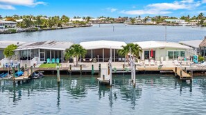 A waterfront property with a dock, lounge chairs, and a pool area. - P15 - Waterfront, ground level duplex with Cabana Club (Key Colony Beach)