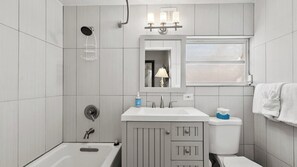 A modern bathroom with a bathtub, a toilet, a sink, and a shower. - P15 - Waterfront, ground level duplex with Cabana Club (Key Colony Beach)