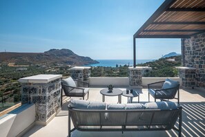 A terrace with a view of the sea, stone walls, and outdoor furniture. - Stone horizon villa (Myrthianos Plakias)