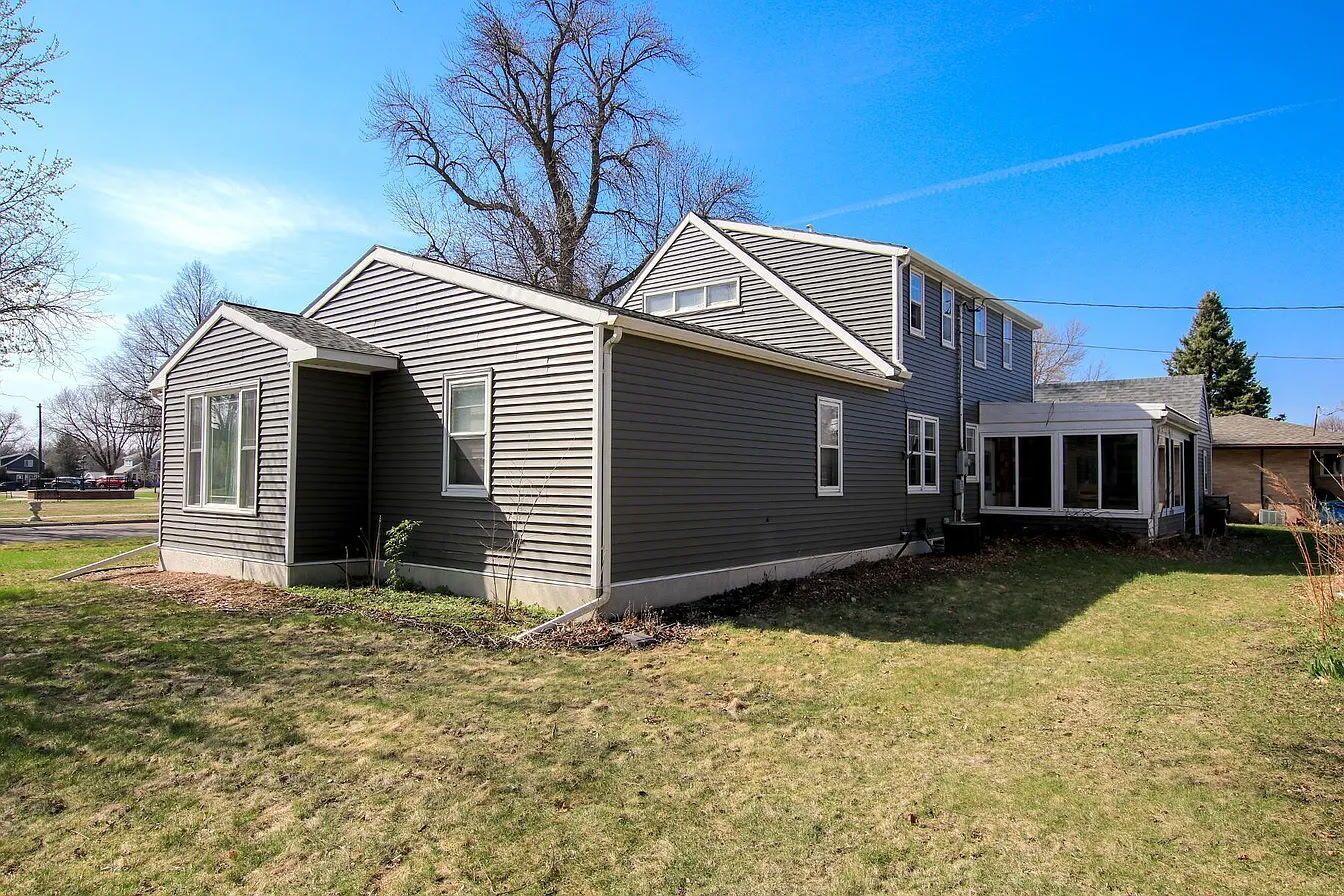A two-story house with a covered porch and a small attached garage.