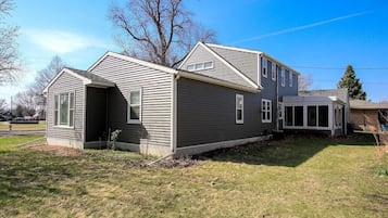A two-story house with a covered porch and a small attached garage.