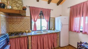 A kitchen with a gas stove, sink, and a refrigerator. - Casa Rural La Higuera El Gastor by Ruralidays (Cádiz)