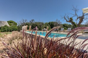 A pool area with lounge chairs and a stone building. - Lovely Villa w/ Pool & Garden, close to beaches (Pescoluse)