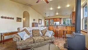 A cozy living room with a sofa, a coffee table, and a fireplace. - Vita Amorosa by Avantstay Gated Cottage + Oak & Vineyard Views Near Paso Robles (Atascadero)