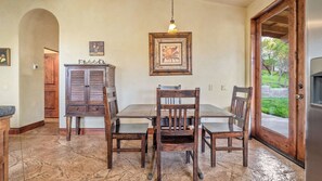 A dining area with a wooden table and chairs, a hanging light fixture, and a door leading outside. - Vita Amorosa by Avantstay Gated Cottage + Oak & Vineyard Views Near Paso Robles (Atascadero)