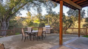 An outdoor patio with a table and chairs, a grill, and a wooden pergola. - Vita Amorosa by Avantstay Gated Cottage + Oak & Vineyard Views Near Paso Robles (Atascadero)