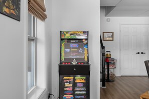 Ein Zimmer mit einem Retro-Arcade-Automaten und verschiedenen Spieltiteln.