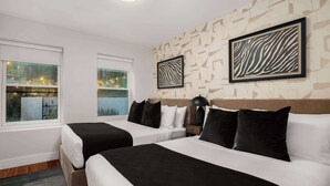 A hotel room with two beds, a large window with a view, and a zebra-patterned artwork on the wall.
